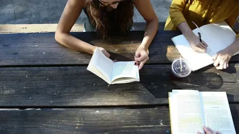 des jeunes étudient sur une table extérieure