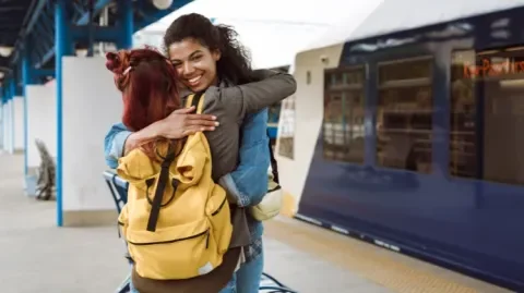 deux femmes s'enlacent avant un départ à l'étranger