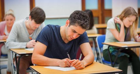 Jeune homme dans une salle d'examen qui passe son bac pro