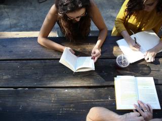 3 jeunes filles en train de lire et d'écrire
