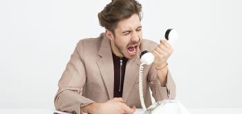 Homme énervé au téléphone pour illustrer la recherche d'emploi en période de crise